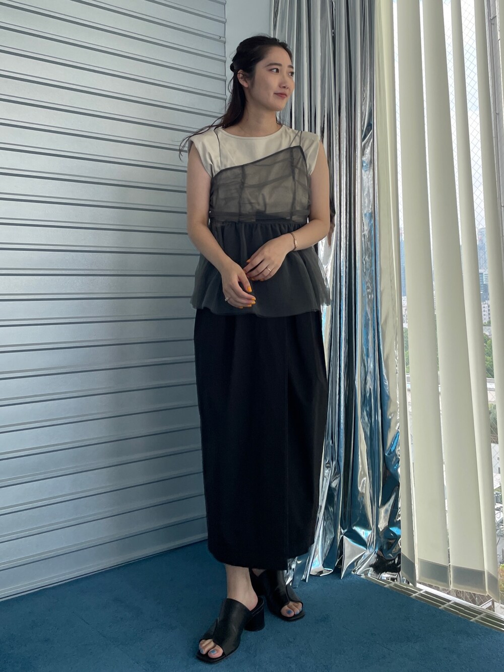 ブラック系のサンダル、ブラック系のスカート、ベージュ系のTシャツ/カットソーを着用したレディースの夏コーディネートの1枚目の写真