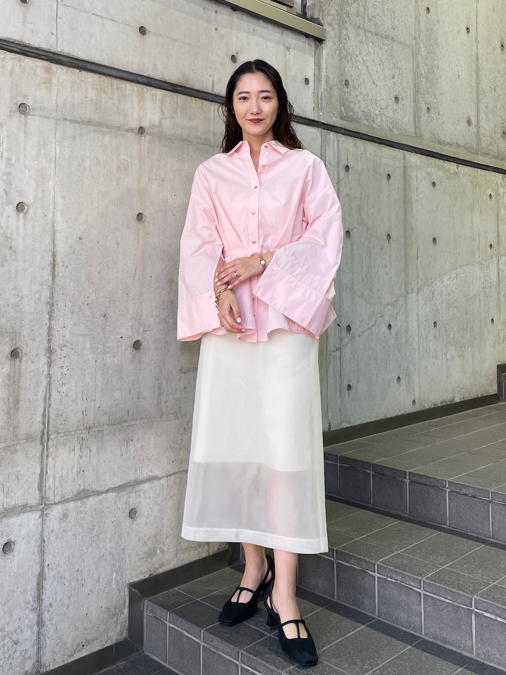 ピンク系のシャツ/ブラウス、ブラック系のパンプス、ホワイト系のスカートを着用したレディースの冬コーディネートの1枚目の写真