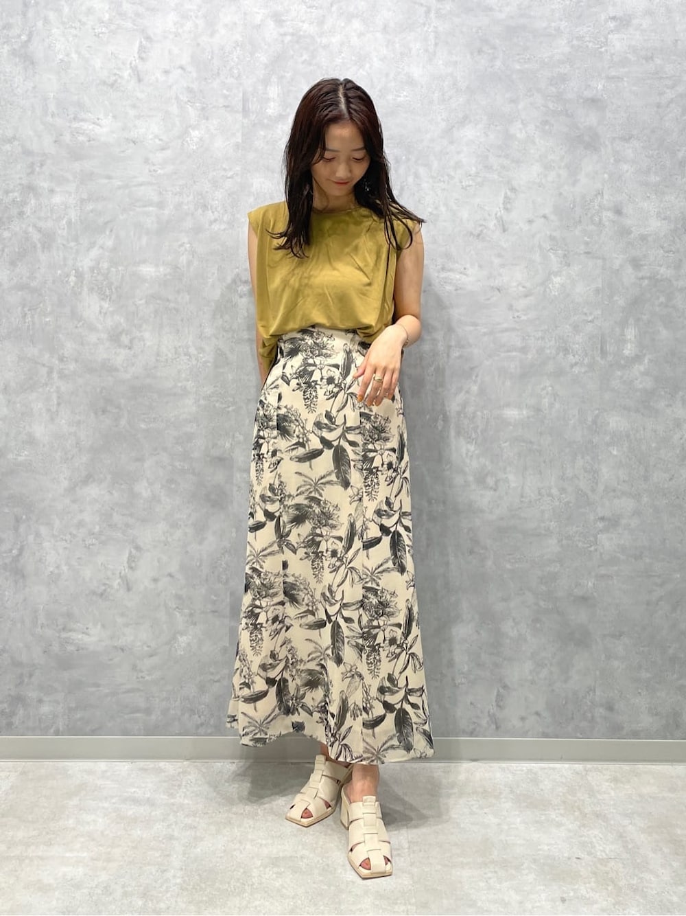 ホワイト系のサンダル、ベージュ系のスカート、ベージュ系のTシャツ/カットソーを着用したレディースの夏コーディネートの1枚目の写真