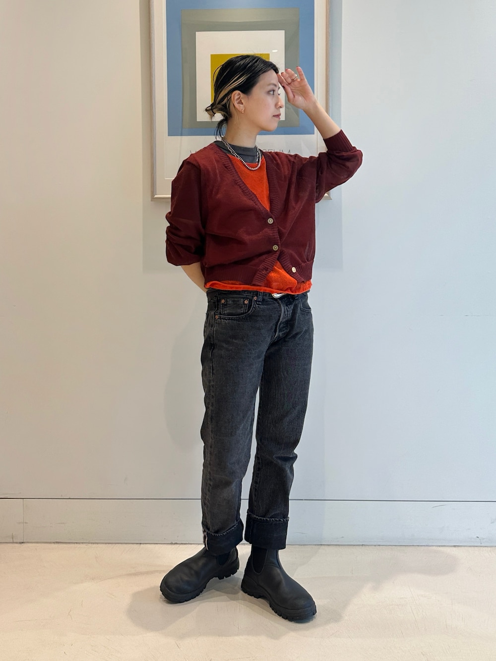 ブラック系のブーツ、レッド系のニット/セーター、ブラック系のTシャツ/カットソーを着用したレディースの春コーディネートの1枚目の写真