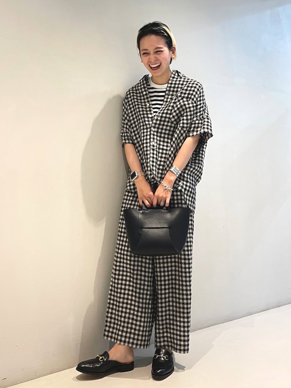 ブラック系のトートバッグ、ブラック系のシャツ/ブラウス、ブラック系のその他パンツを着用したレディースの春コーディネートの1枚目の写真