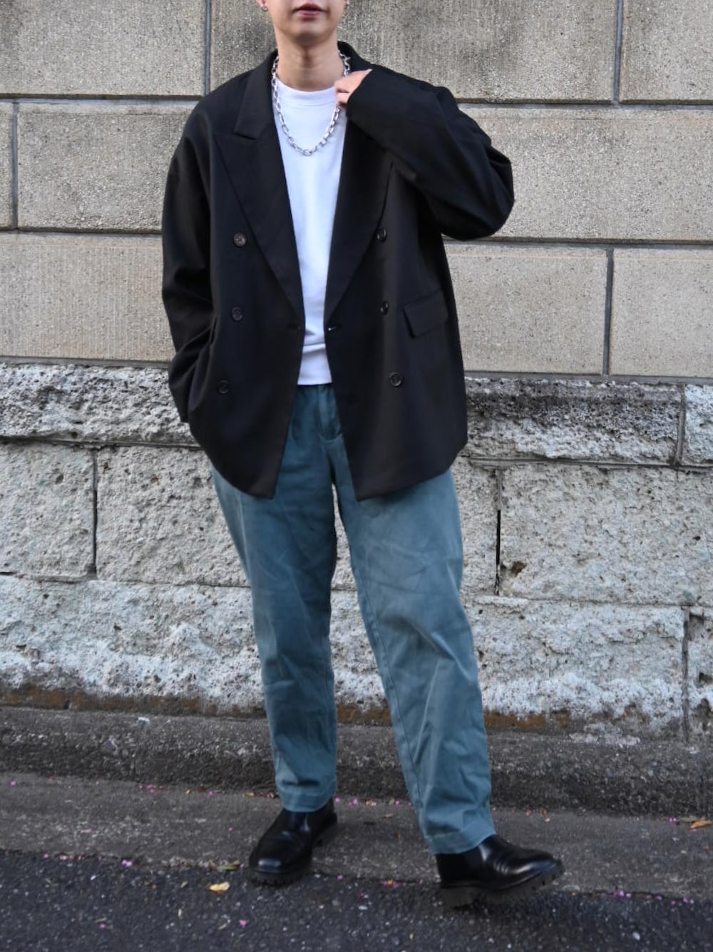 ブルー系のチノパンツ、ブラック系のスリッポン、ブラック系のテーラードジャケットを着用したメンズの冬コーディネートの1枚目の写真