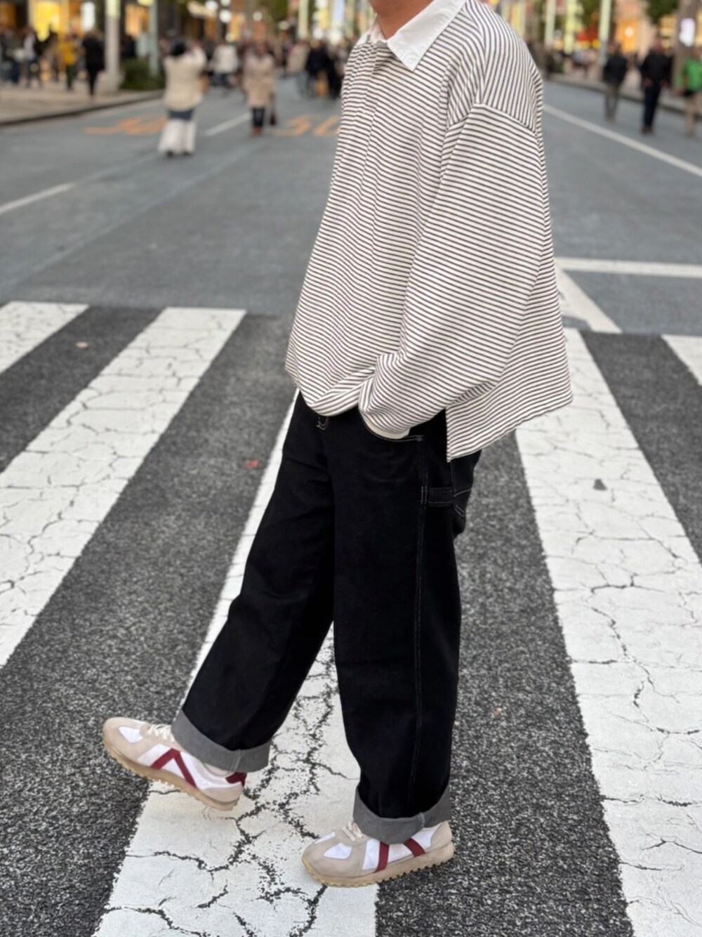 ホワイト系のスウェット、ブラック系のデニムパンツ、ベージュ系のスニーカーを着用したメンズの秋コーディネートの1枚目の写真