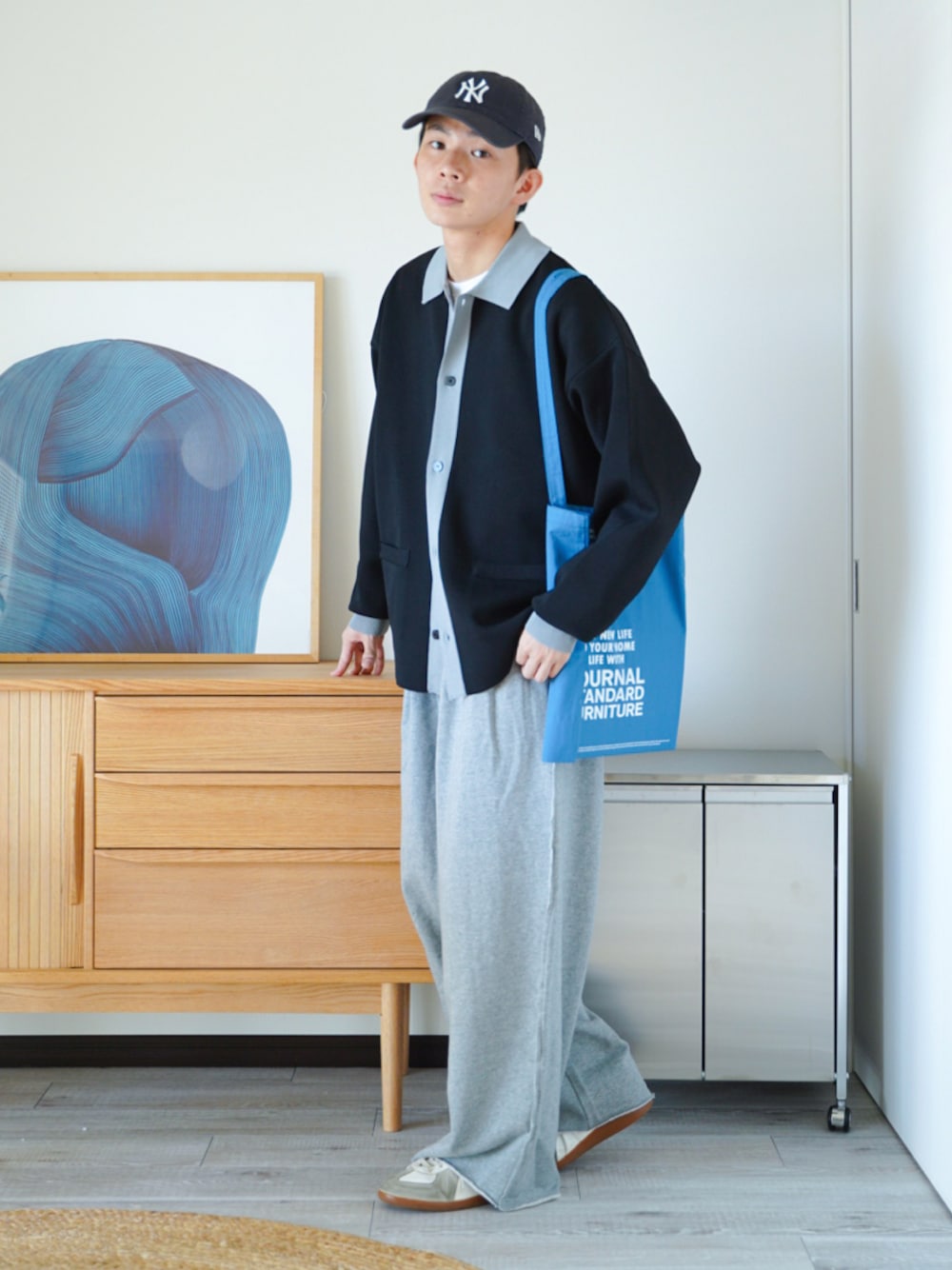 ブラック系のポロシャツ、ホワイト系のTシャツ/カットソー、ブルー系のトートバッグを着用したメンズの秋コーディネートの1枚目の写真