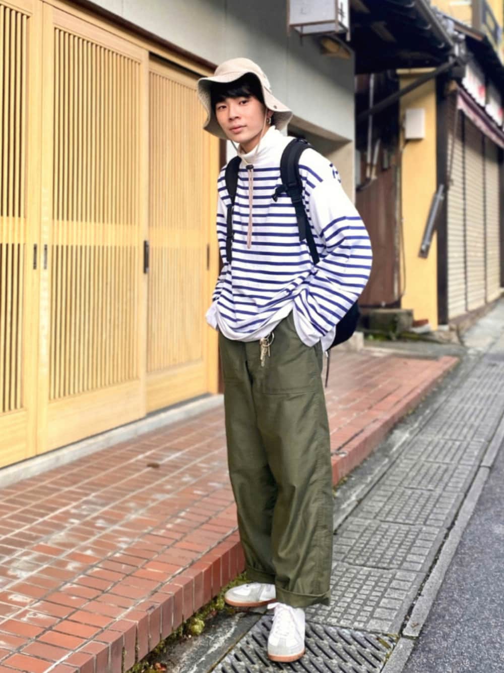 「ビッグシルエット、ボーダー、ロンT、バスクシャツ、休日スタイル、バケットハット、プチプラ、古着MIX、リュック、白スニーカー、カーキ、タートルネック、UNIQLO、レイヤードスタイル、オーバーサイズ」｜「CIOTAの【CIOTA / シオタ】バックサテン ベイカーパンツ（その他パンツ、グリーン系）」を使った、idakaさん（メンズ・171cm）の秋コーディネートの1枚目の写真
