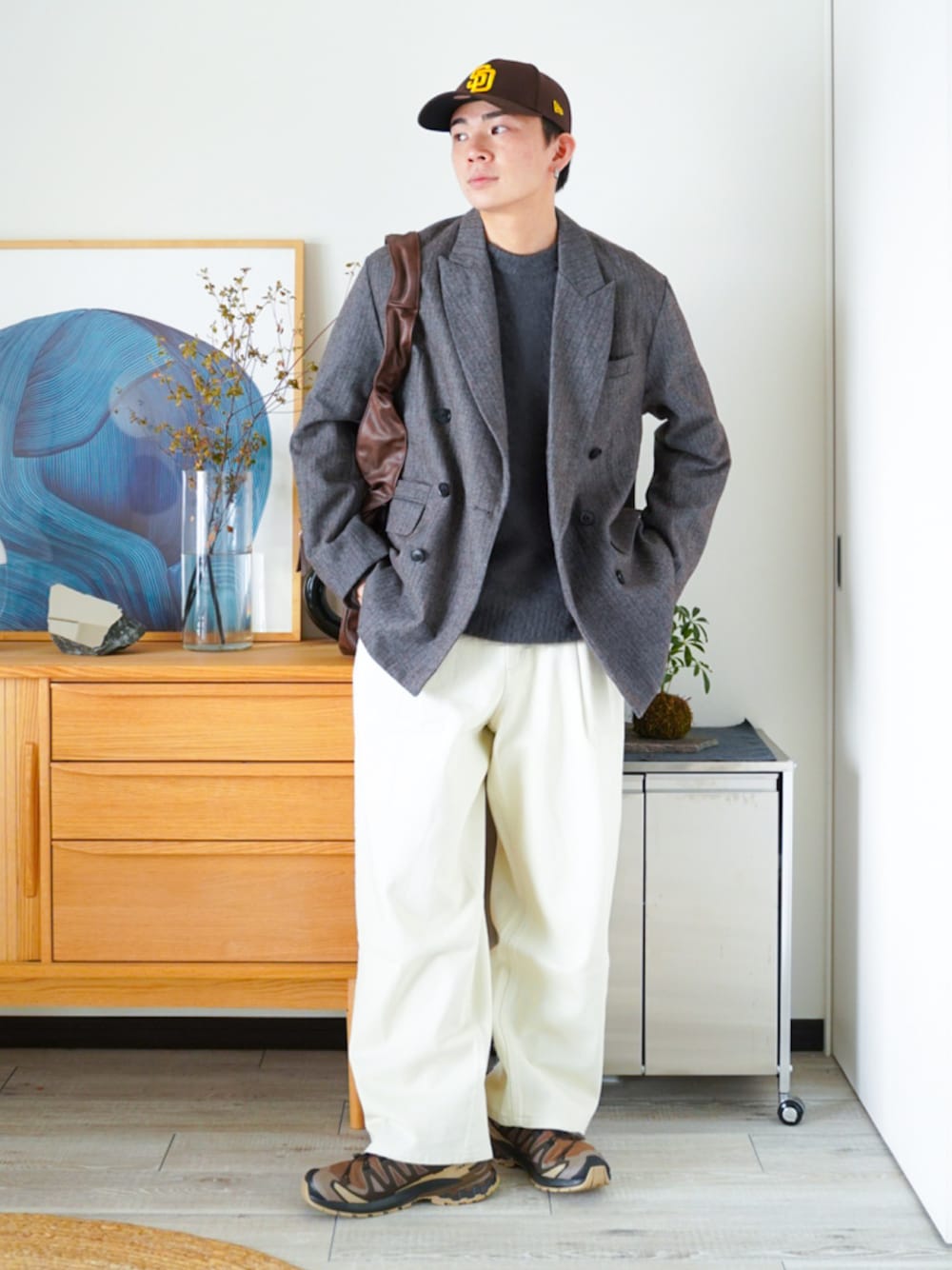 ブラウン系のテーラードジャケット、グレー系のニット/セーター、ホワイト系のデニムパンツを着用したメンズの秋コーディネートの1枚目の写真