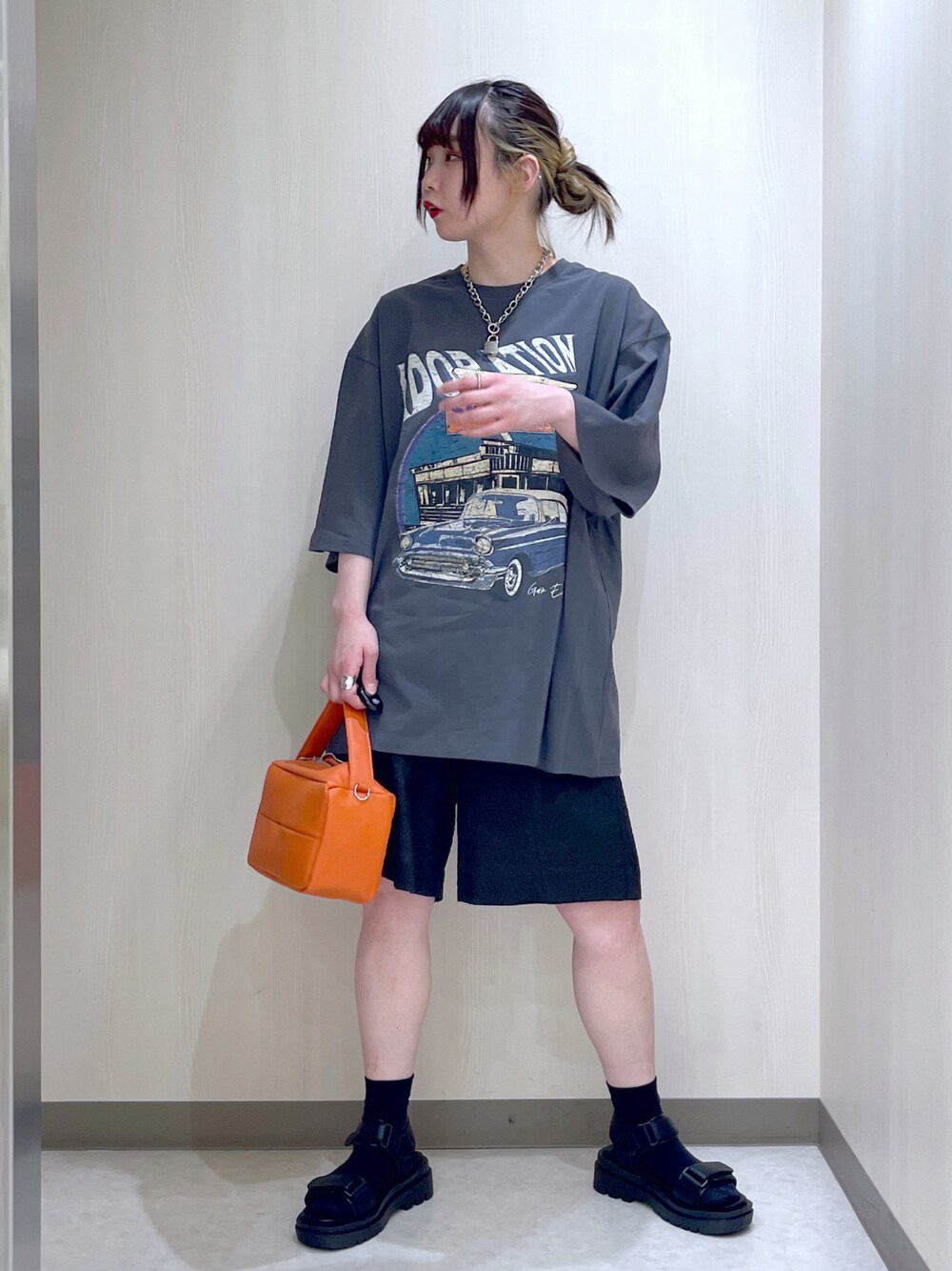 グレー系のTシャツ/カットソー、ブラック系のその他パンツ、オレンジ系のショルダーバッグを着用したレディースの春コーディネートの1枚目の写真