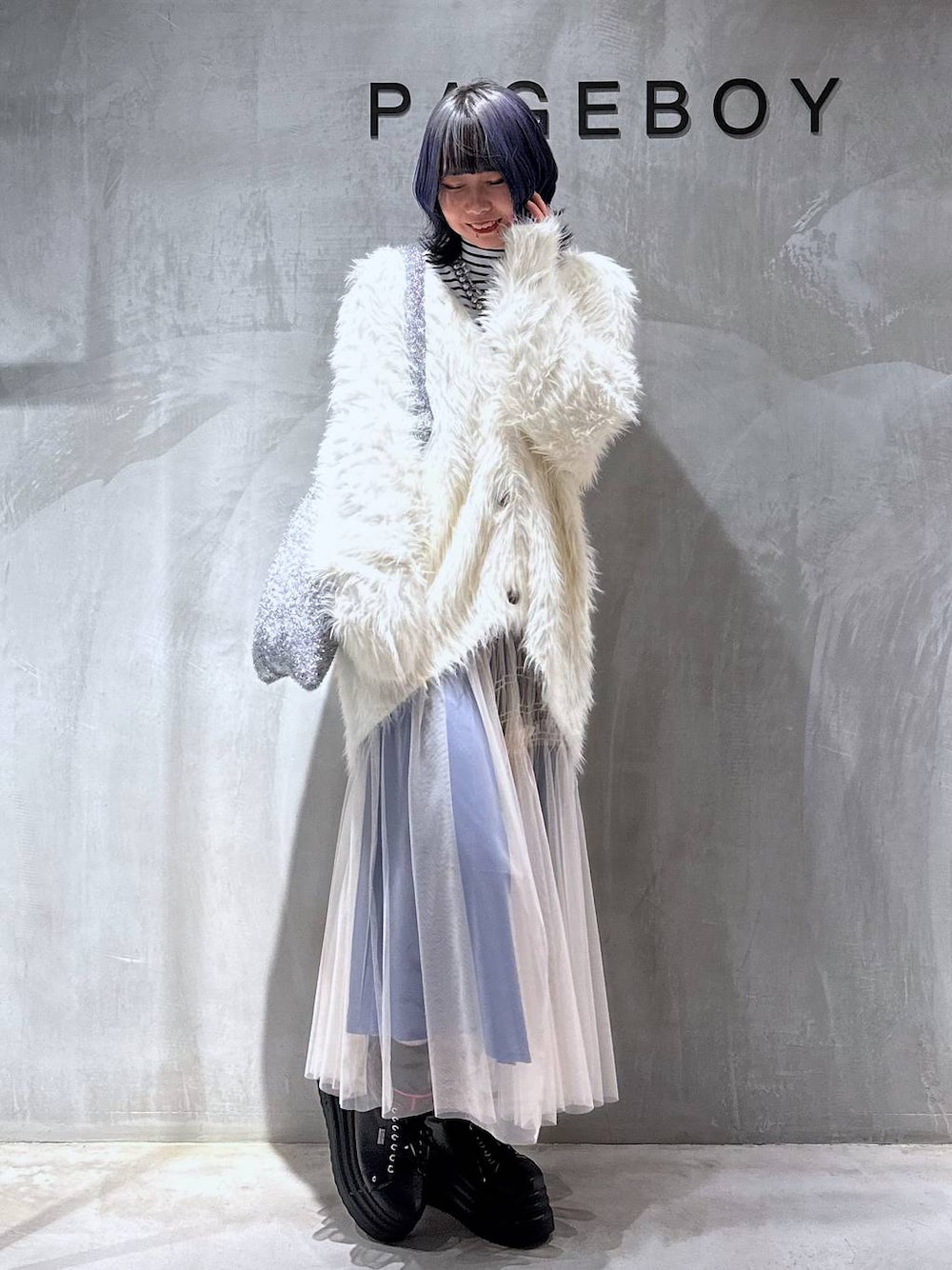 シルバー系のトートバッグ、ホワイト系のカーディガン/ボレロ、ホワイト系のスカートを着用したレディースの秋コーディネートの1枚目の写真