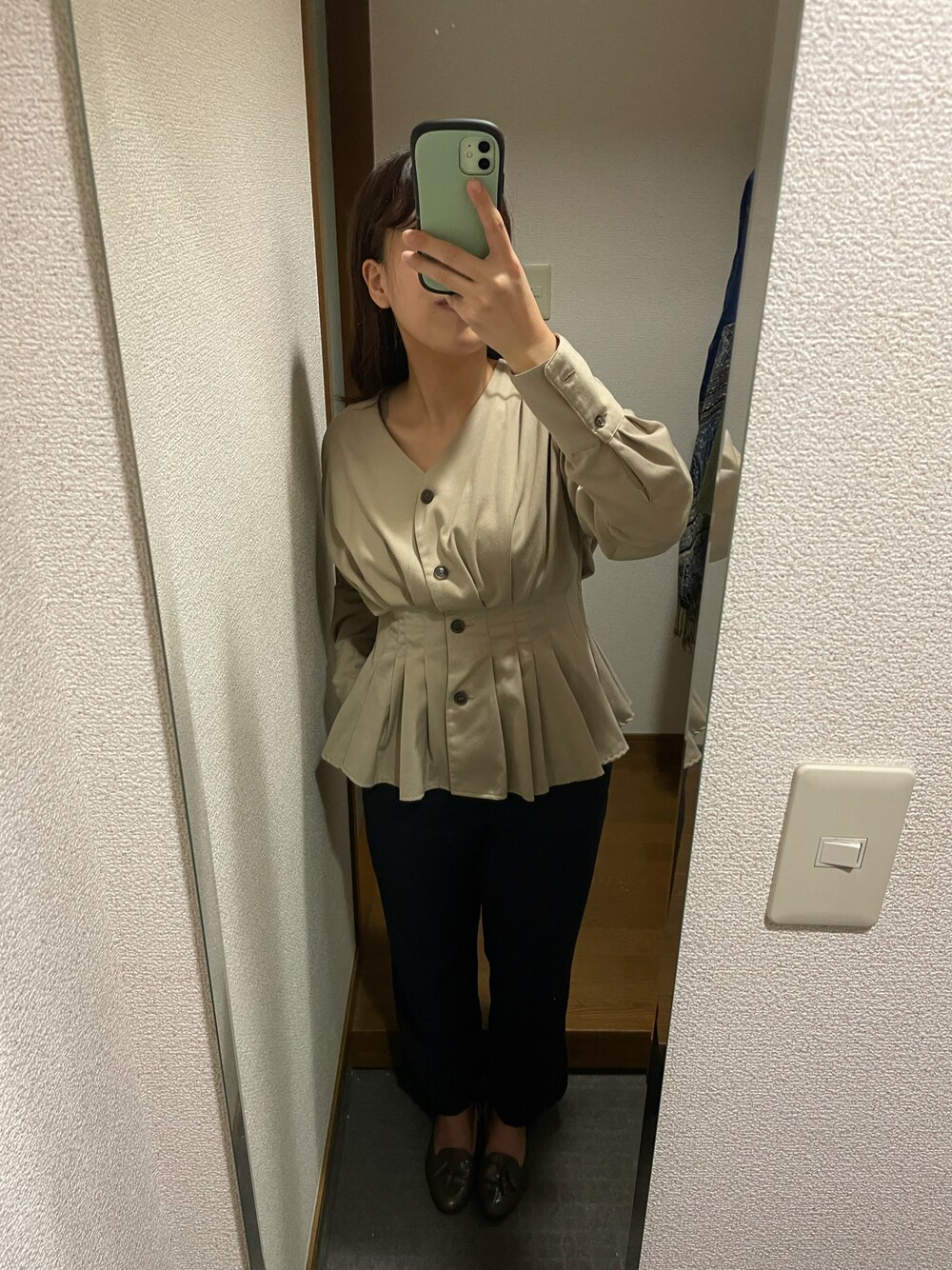 ブラウン系のレインシューズ、ブラック系のスラックスを着用したレディースの秋コーディネートの1枚目の写真