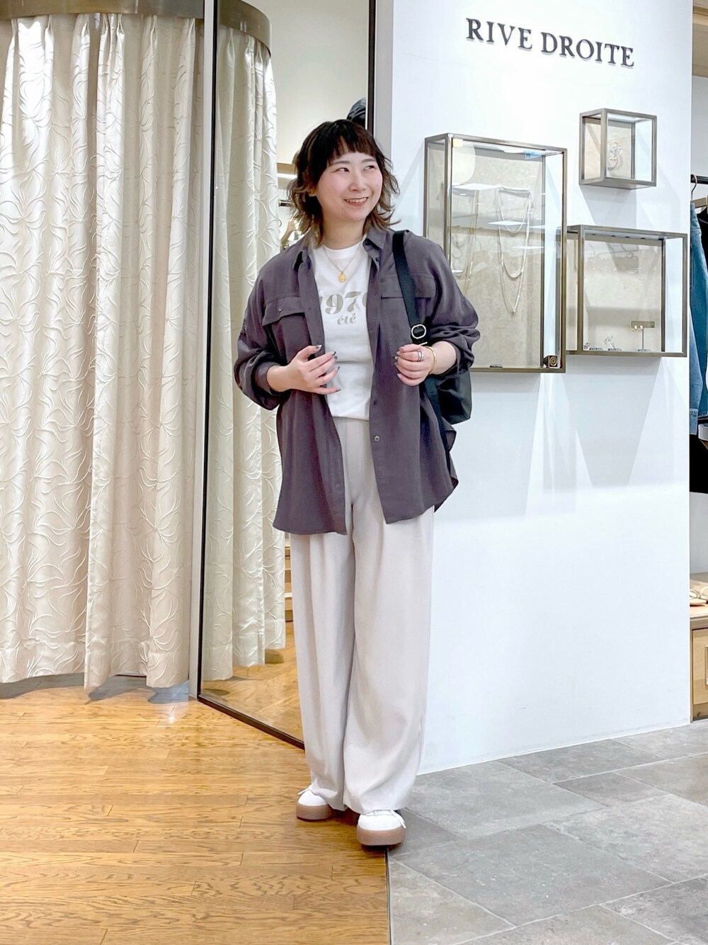 グレー系のスラックス、グレー系のシャツ/ブラウス、ホワイト系のTシャツ/カットソーを着用したレディースの春コーディネートの1枚目の写真