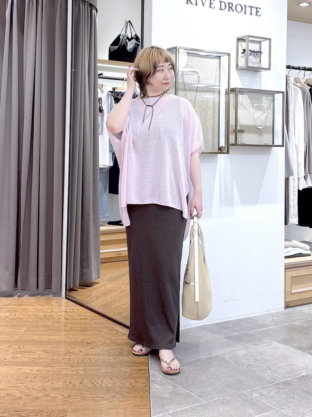 ブラウン系のワンピース、ピンク系のニット/セーター、ベージュ系のショルダーバッグを着用したレディースの夏コーディネートの1枚目の写真