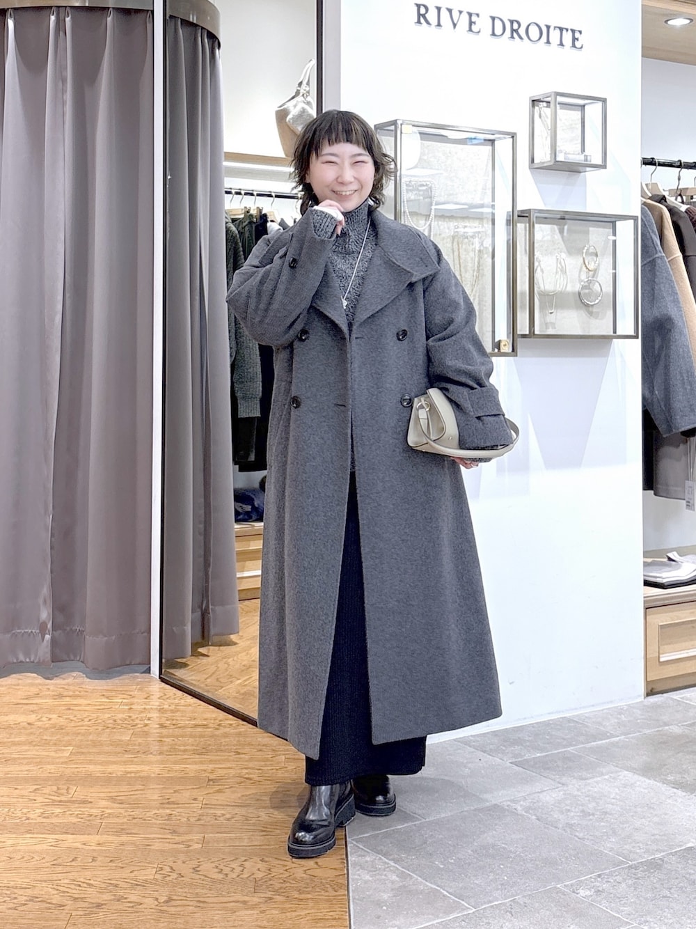 グレー系のニット/セーター、ベージュ系のハンドバッグ、グレー系のその他アウターを着用したレディースの秋コーディネートの1枚目の写真