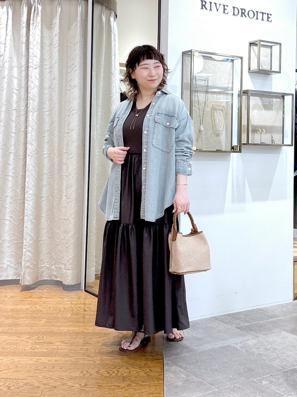 ブラウン系のワンピース、ブラウン系のハンドバッグ、ブルー系のシャツ/ブラウスを着用したレディースの夏コーディネートの1枚目の写真