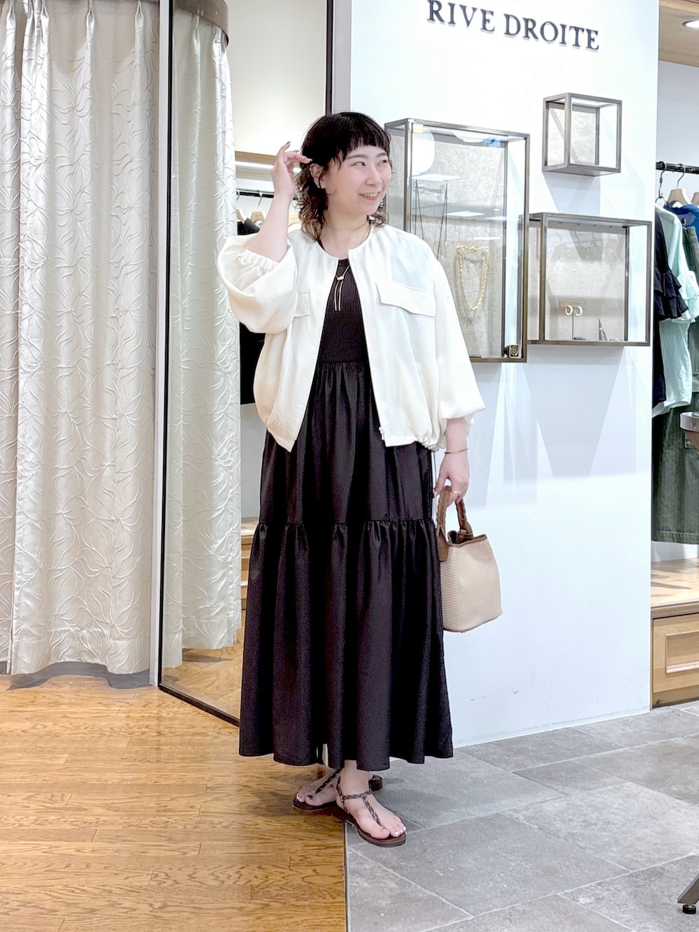 ホワイト系のブルゾン、ブラウン系のワンピース、ブラウン系のハンドバッグを着用したレディースの夏コーディネートの1枚目の写真