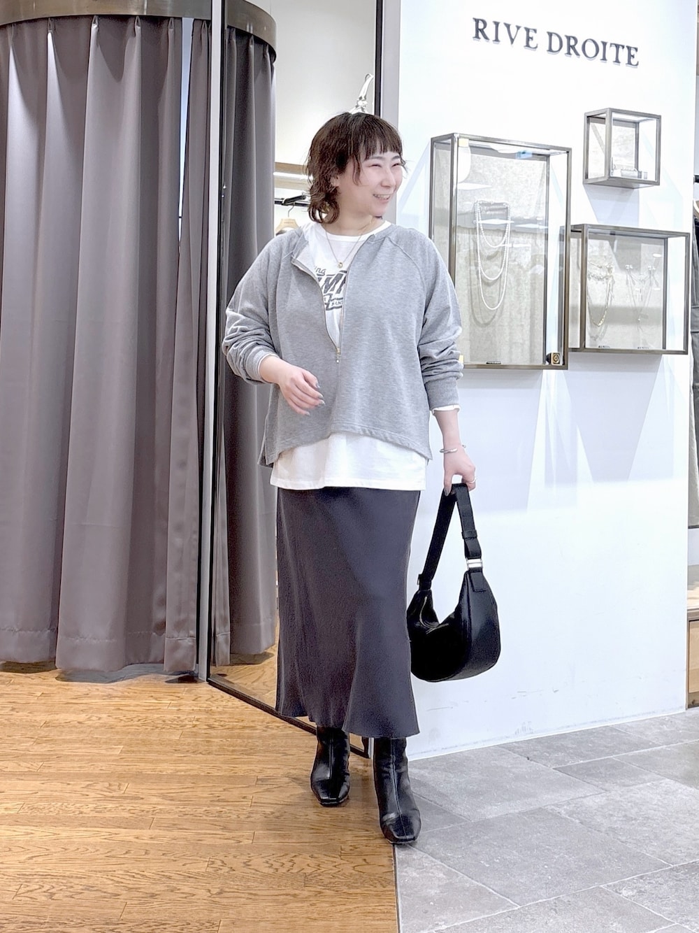 グレー系のスウェット、ホワイト系のTシャツ/カットソー、ブラック系のショルダーバッグを着用したレディースの秋コーディネートの1枚目の写真