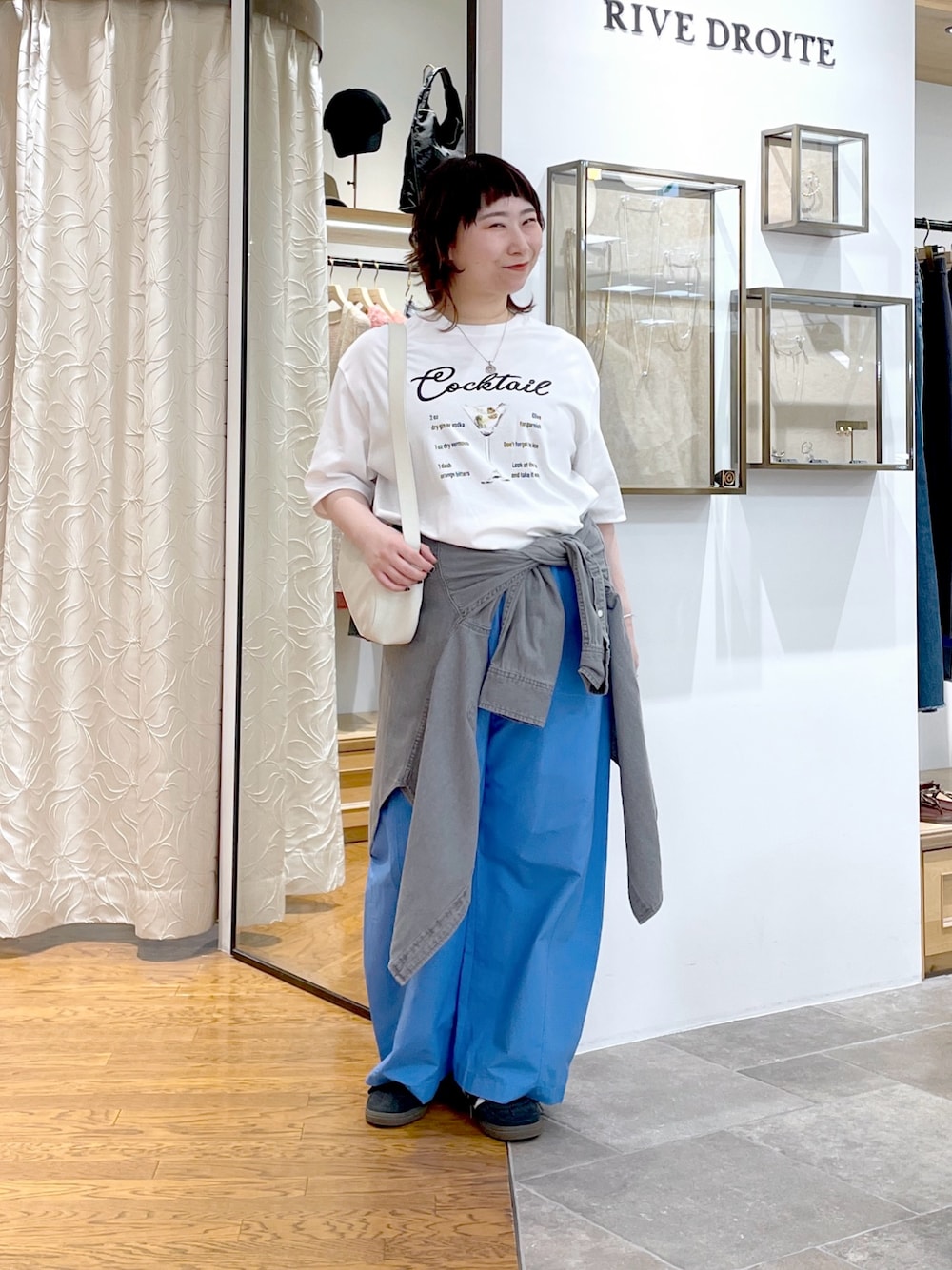 ホワイト系のTシャツ/カットソー、ホワイト系のハンドバッグ、グレー系のシャツ/ブラウスを着用したレディースの夏コーディネートの1枚目の写真