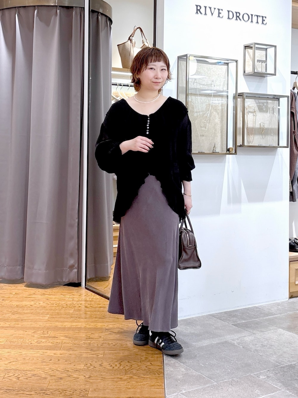 ブラック系のシャツ/ブラウス、ブラウン系のボストンバッグ、グレー系のスカートを着用したレディースの秋コーディネートの1枚目の写真