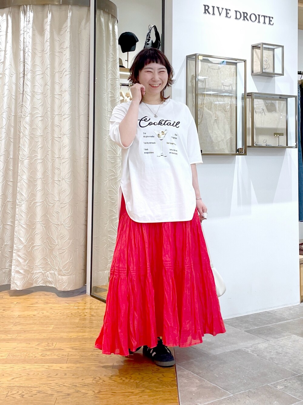 ホワイト系のハンドバッグ、ホワイト系のTシャツ/カットソー、レッド系のスカートを着用したレディースの春コーディネートの1枚目の写真