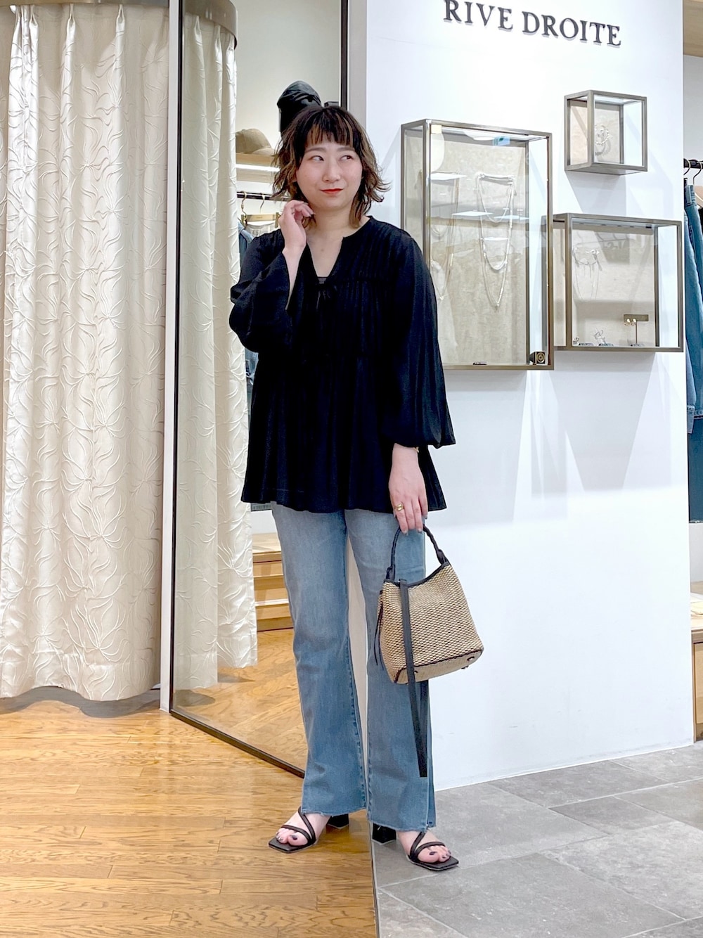 ブラウン系のキャミソール、ブラック系のシャツ/ブラウス、ブラック系のハンドバッグを着用したレディースの春コーディネートの1枚目の写真