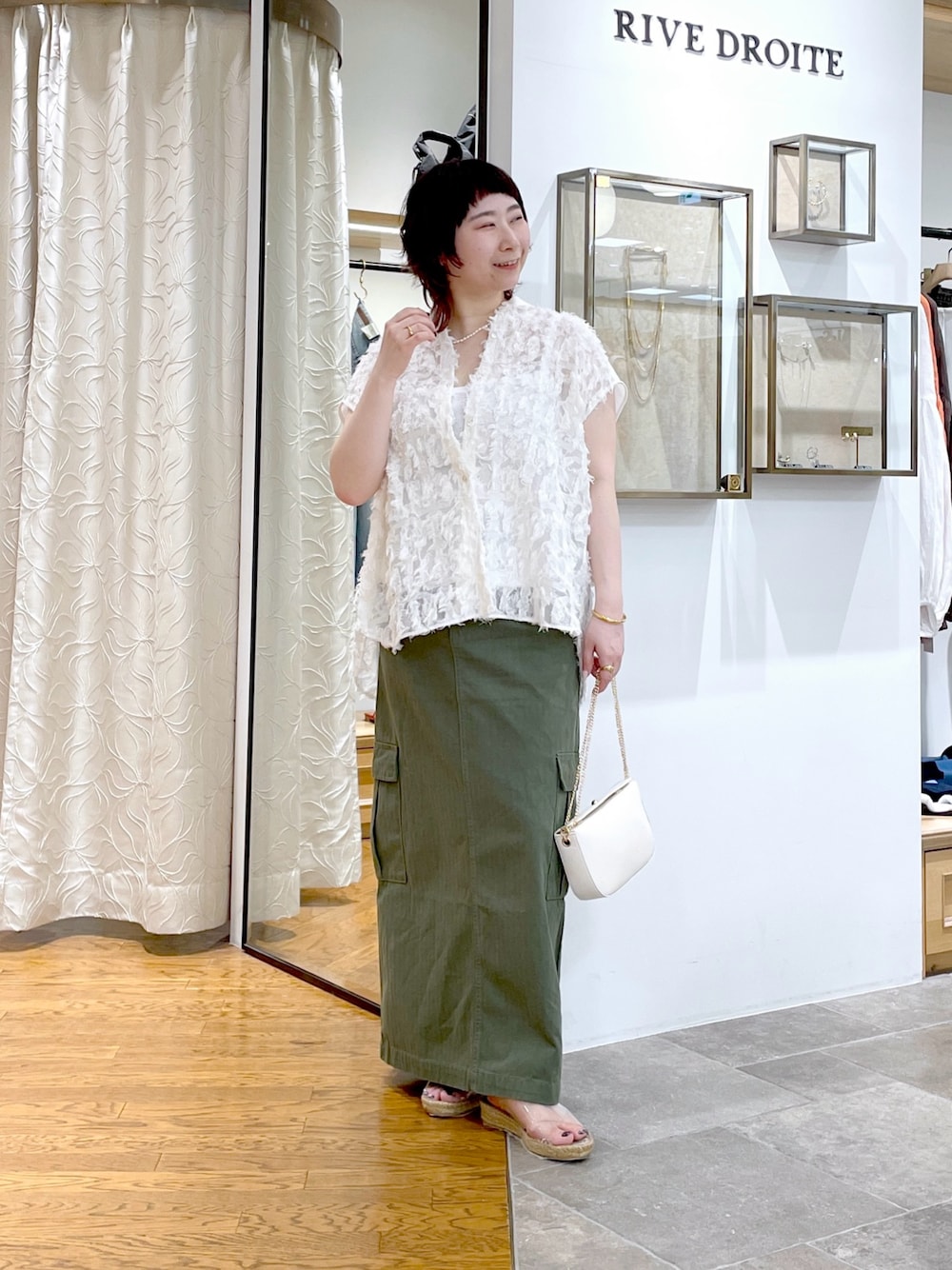 グレー系のキャミソール、ホワイト系のシャツ/ブラウス、グリーン系のスカートを着用したレディースの春コーディネートの1枚目の写真