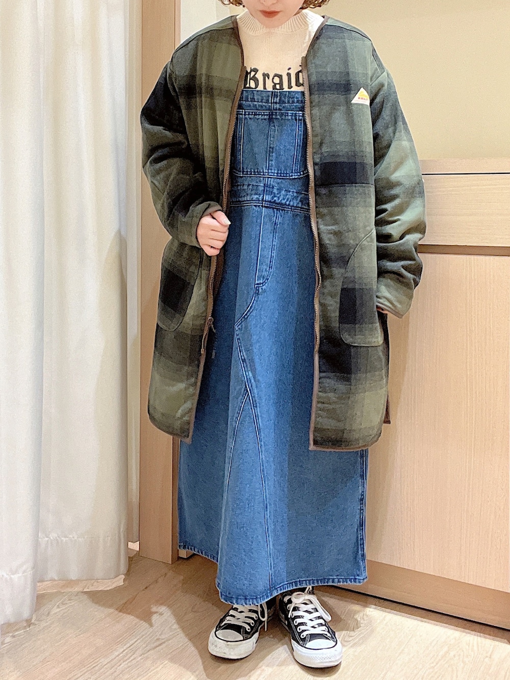 ホワイト系のニット/セーター、ブルー系のジャンパースカート、グリーン系のその他アウターを着用したレディースの秋コーディネートの1枚目の写真