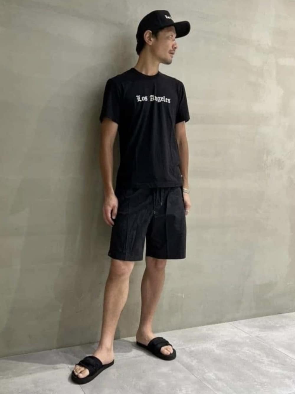 「TOMORROWLAND、トゥモローランド、JAMES PERSE、プリントT、ハーフパンツ、キャップ、オールブラック、大人カジュアル、リラックススタイル、デイリーカジュアル」｜「JAMES PERSEのLOS ANGELES グラフィックTシャツ MLJ3311LOS（Tシャツ/カットソー、ホワイト系）」を使った、Nishio_TOMORROWLANDさん（メンズ・183cm）の夏コーディネートの1枚目の写真