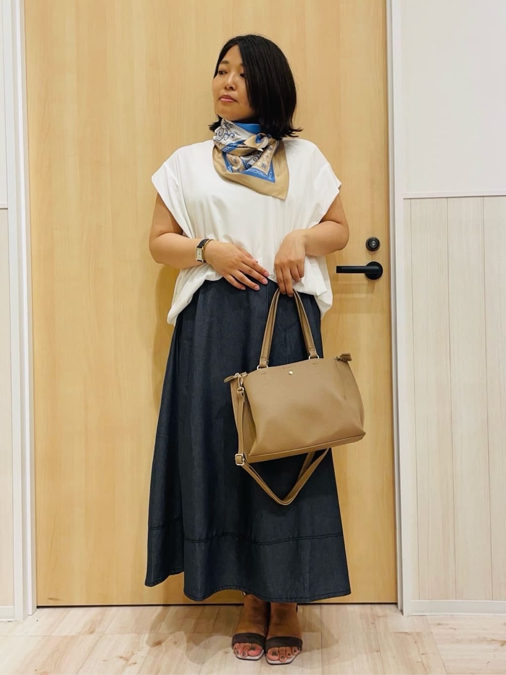 ホワイト系のTシャツ/カットソー、ブラック系のスカート、ベージュ系のサンダルを着用したレディースの夏コーディネートの1枚目の写真