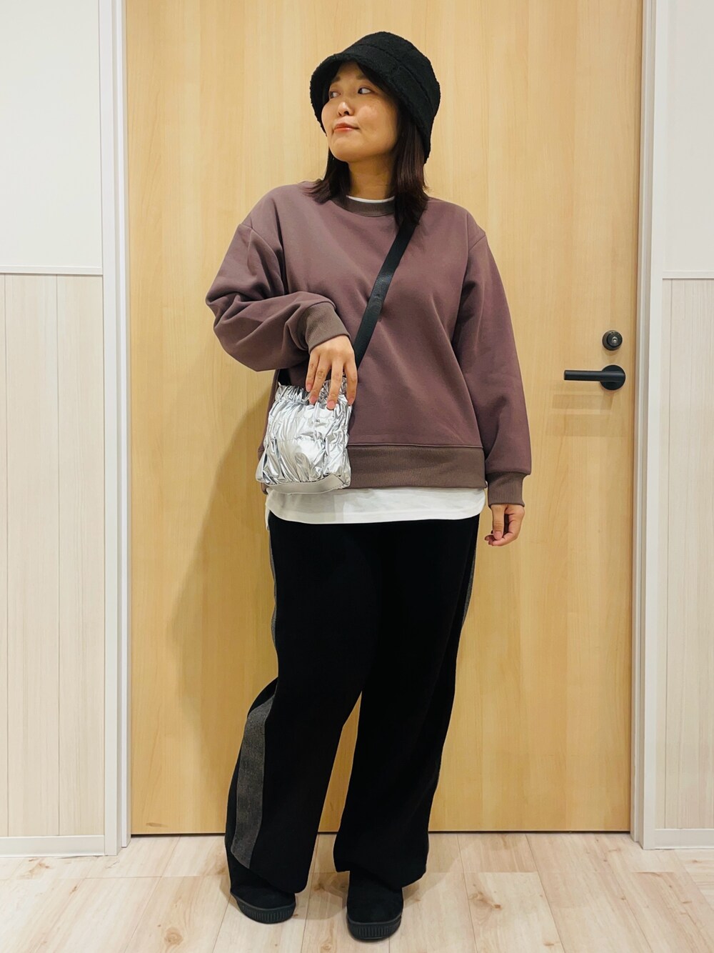 ブラック系のその他パンツ、シルバー系のショルダーバッグ、ブラック系のブーツを着用したレディースの冬コーディネートの1枚目の写真