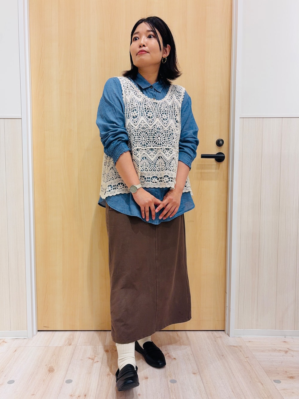 ブルー系のシャツ/ブラウス、ブラウン系のスカート、ブラック系のパンプスを着用したレディースの秋コーディネートの1枚目の写真