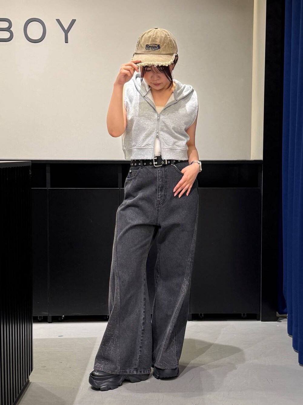 ブラック系のスニーカー、ホワイト系のキャミソール、ブラック系のデニムパンツを着用したレディースの夏コーディネートの1枚目の写真