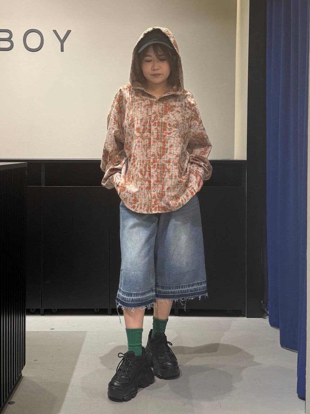 ブラック系のスニーカー、ブルー系のデニムパンツ、オレンジ系のシャツ/ブラウスを着用したレディースの夏コーディネートの1枚目の写真