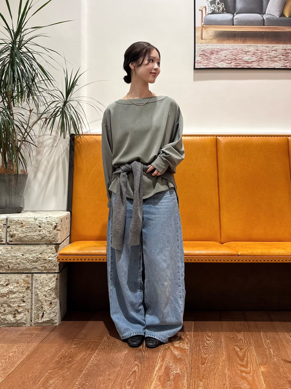 グリーン系のTシャツ/カットソー、ブルー系のデニムパンツ、グレー系のストール/ショールを着用したレディースの秋コーディネートの1枚目の写真