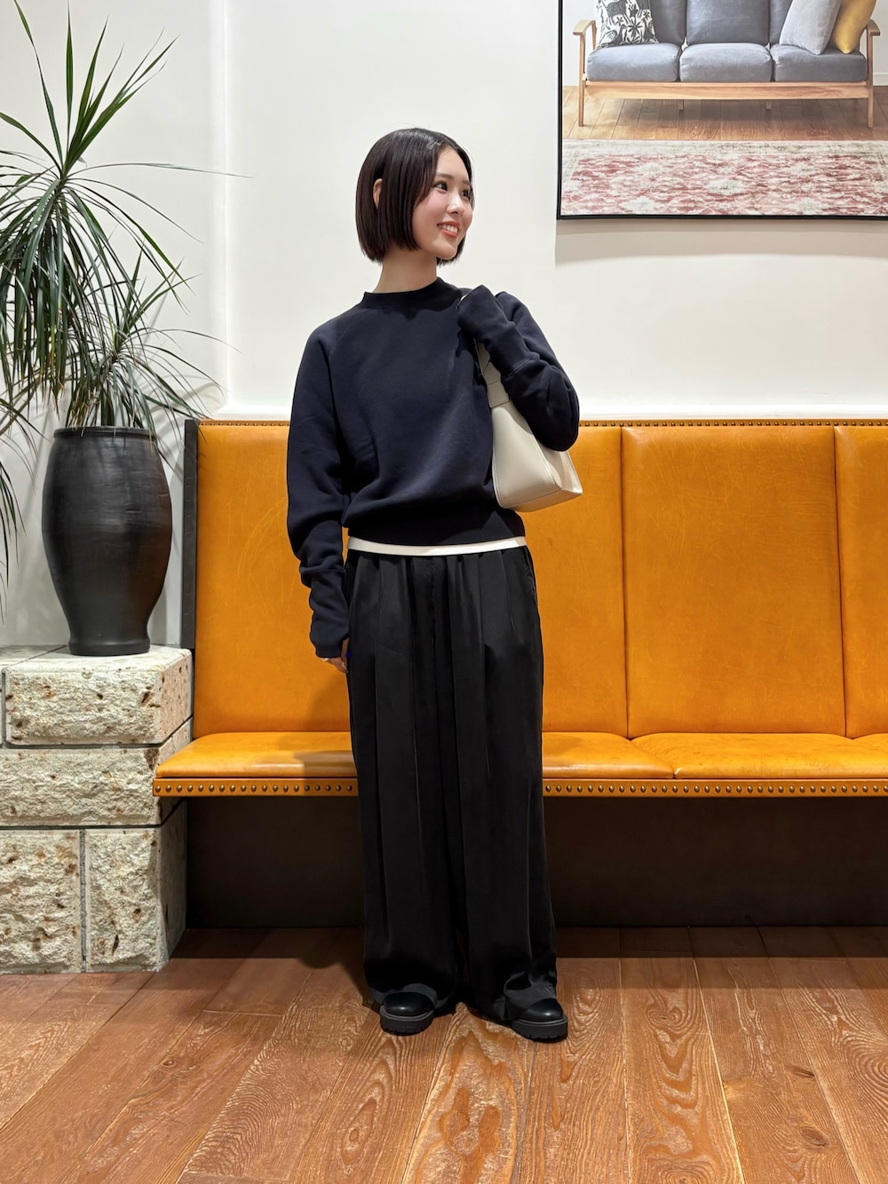 ブラック系のその他パンツ、ブラック系のブーツ、グレー系のハンドバッグを着用したレディースの秋コーディネートの1枚目の写真