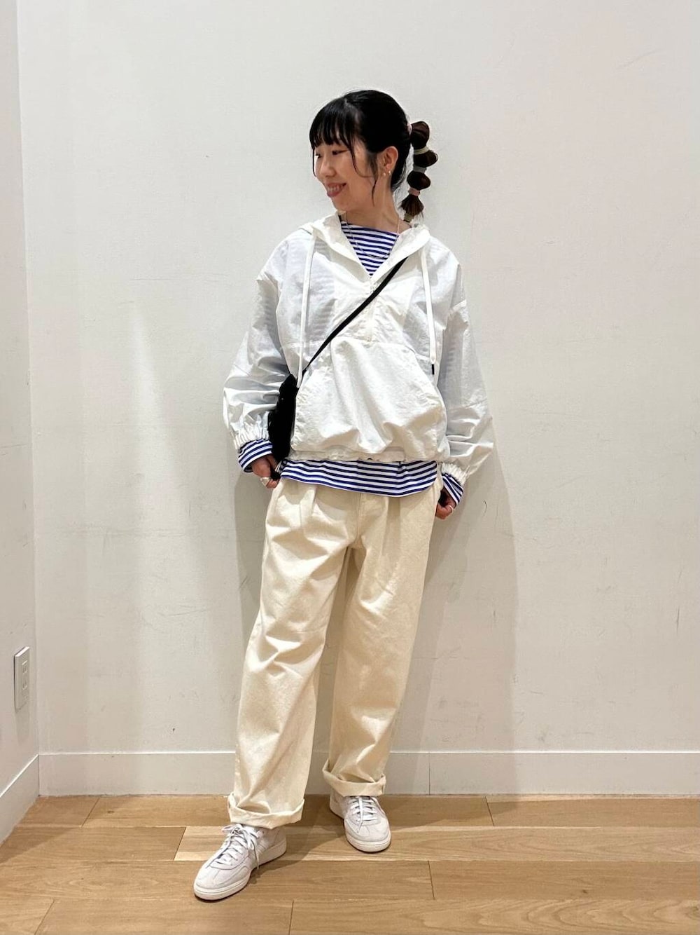 ホワイト系のデニムパンツ、ホワイト系のパーカー、ブルー系のTシャツ/カットソーを着用したレディースの春コーディネートの1枚目の写真