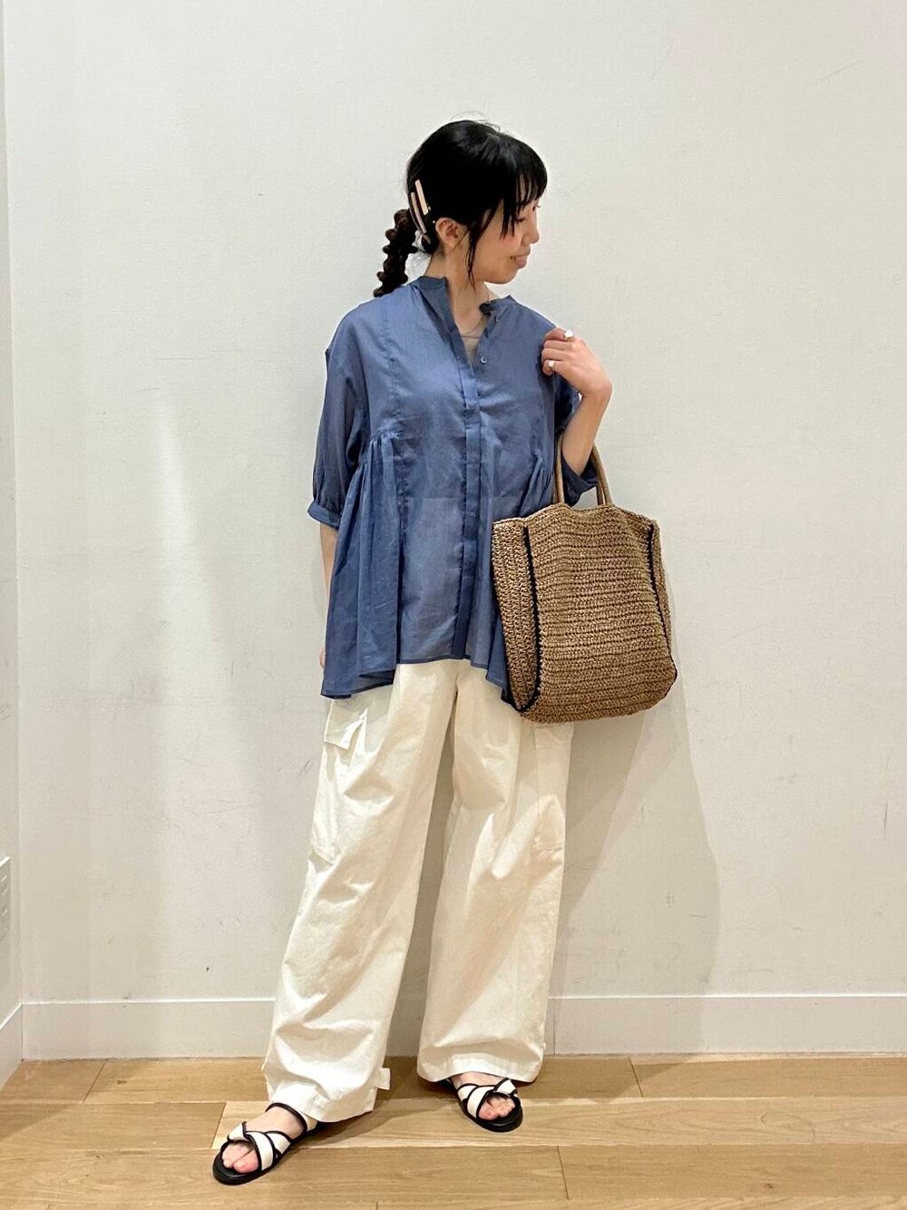 ベージュ系のトートバッグ、ホワイト系のサンダル、ベージュ系のタンクトップを着用したレディースの春コーディネートの1枚目の写真