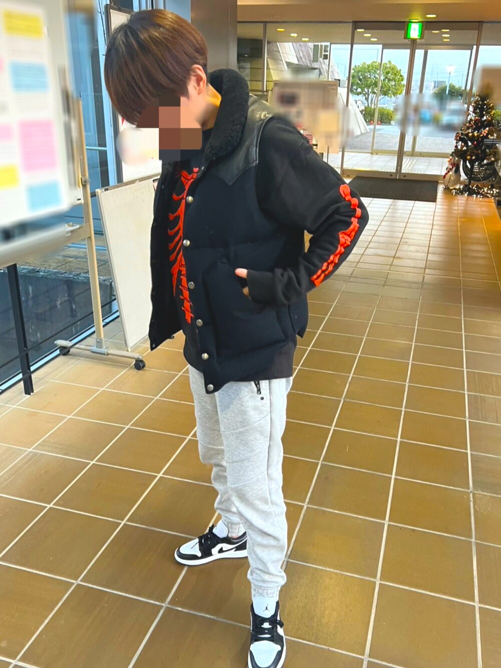 ブラック系のダウンベスト、グレー系のスウェットパンツ、ブラック系のスニーカーを着用したレディースの冬コーディネートの1枚目の写真