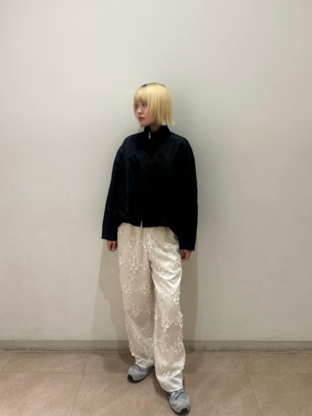 ブラック系のブルゾン、ホワイト系のその他パンツ、グレー系のスニーカーを着用したレディースの春コーディネートの1枚目の写真