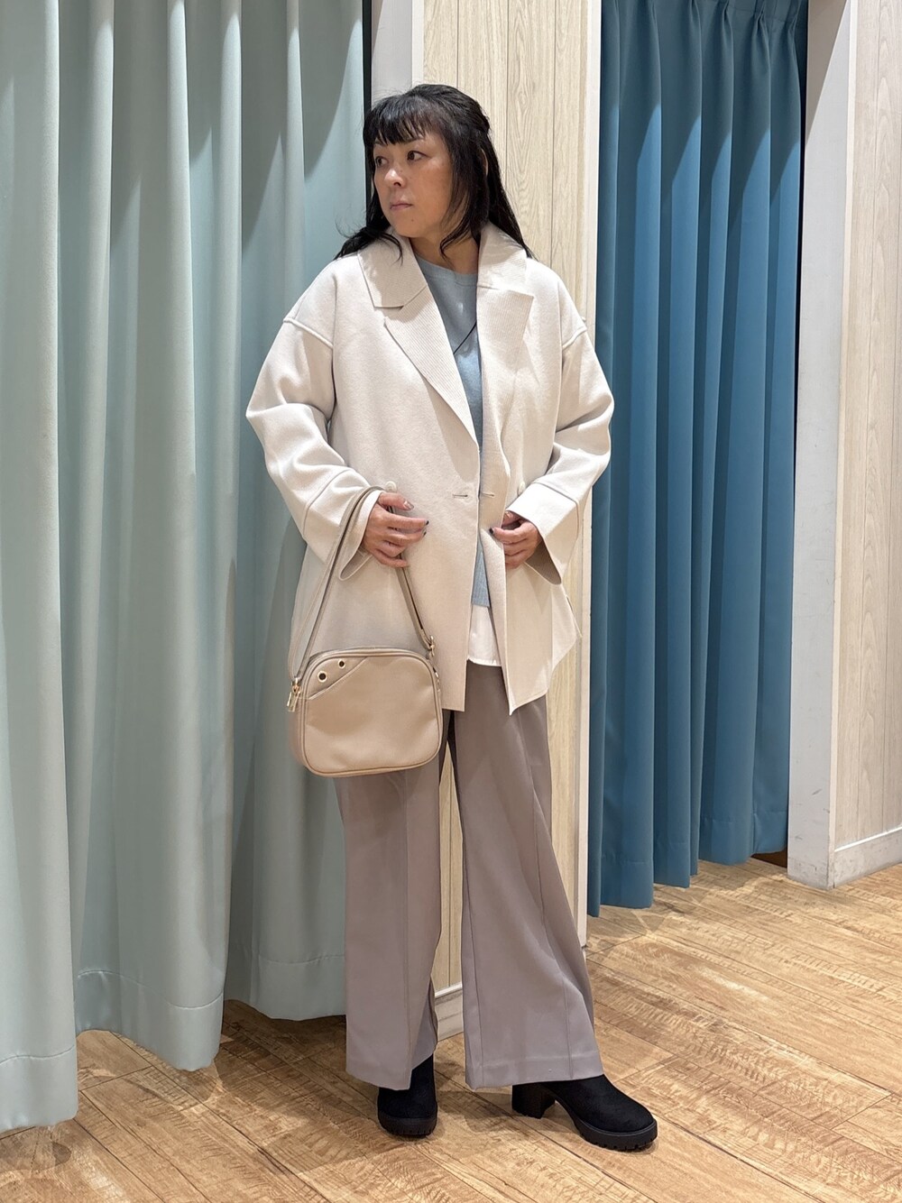 ホワイト系のテーラードジャケット、グリーン系のニット/セーター、グレー系のその他パンツを着用したレディースの秋コーディネートの1枚目の写真