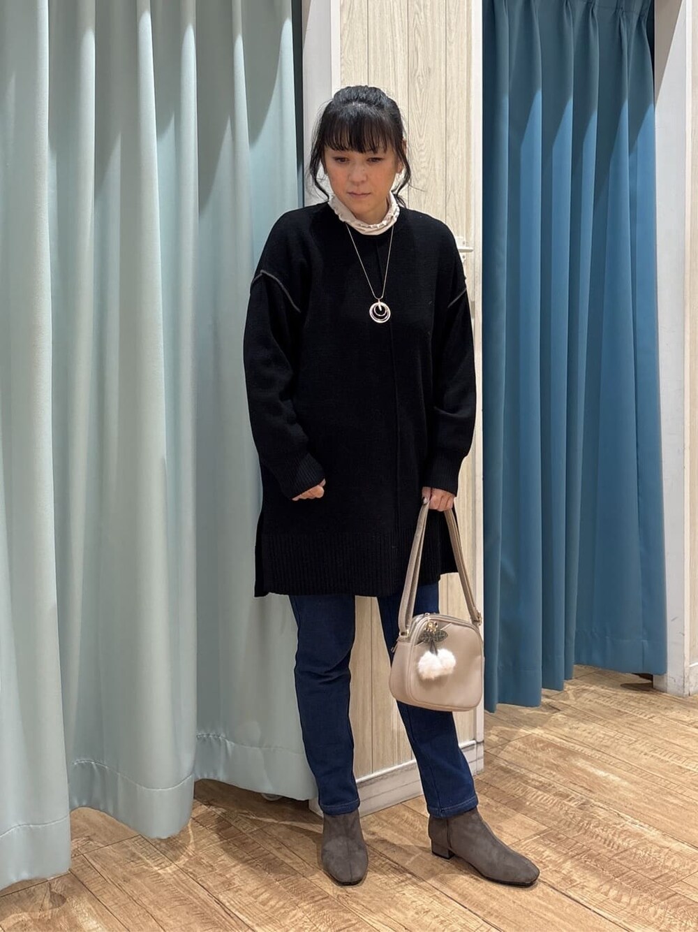 ブラック系のチュニック、ベージュ系のTシャツ/カットソー、ブルー系のその他パンツを着用したレディースの冬コーディネートの1枚目の写真