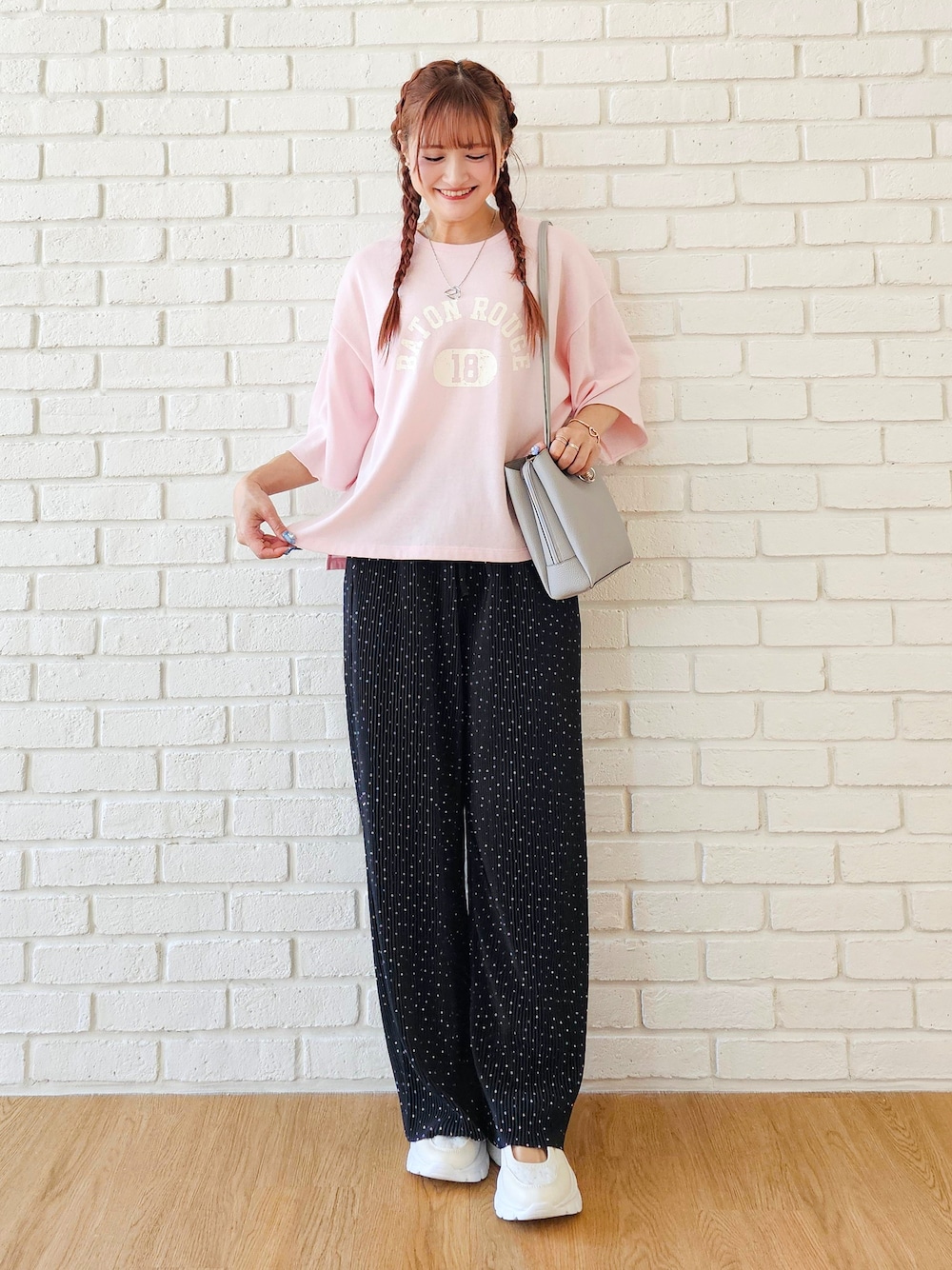 ピンク系のTシャツ/カットソー、ブラック系のその他パンツ、ホワイト系のスニーカーを着用したレディースの春コーディネートの1枚目の写真