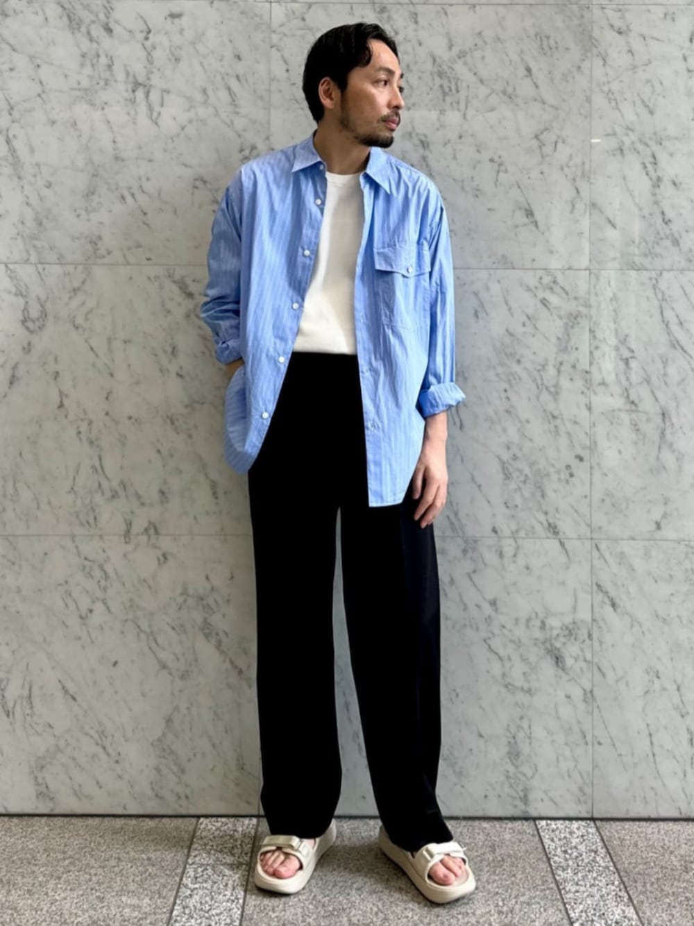 「TOMORROWLAND、トゥモローランド、TOMORROWLAND tricot、caban、suicoke、SUICOKE for TOMORROWLAND、別注、ブルーシャツ、シャツスタイル、大人カジュアル」｜「cabanのCABaN コットンツイル 2タックワイドパンツ（その他パンツ、ブラック系）」を使った、Sawada_TOMORROWLANDさん（メンズ・168cm）の春コーディネートの1枚目の写真