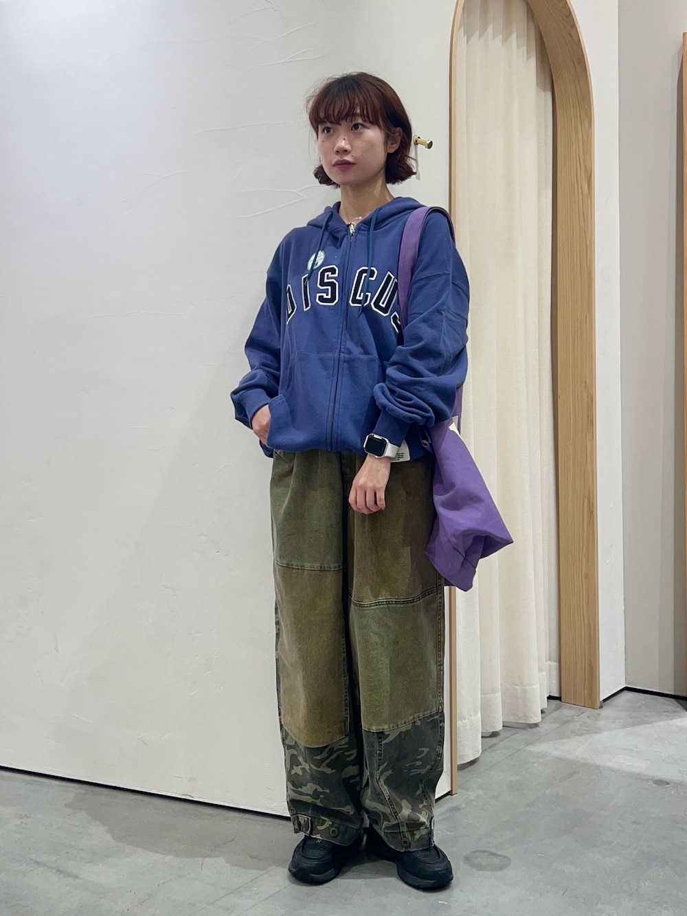 ブルー系のパーカー、パープル系のトートバッグ、グリーン系のその他パンツを着用したレディースの秋コーディネートの1枚目の写真