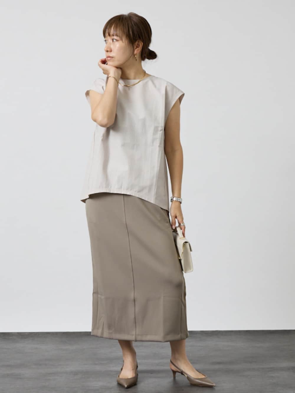 グレー系のシャツ/ブラウス、ベージュ系のスカートを着用したレディースの秋コーディネートの1枚目の写真