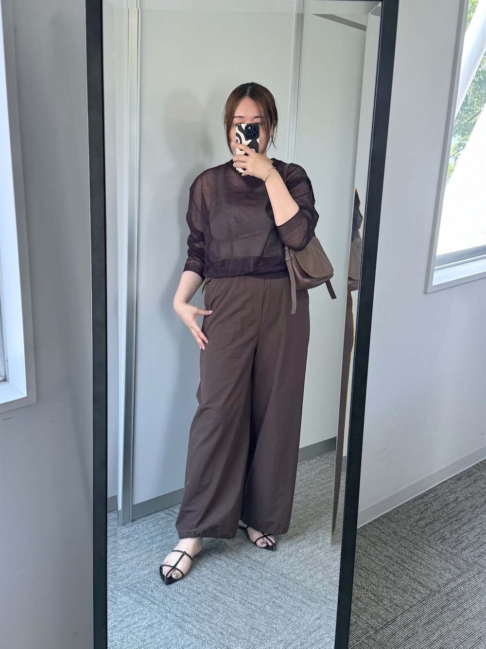 レッド系のニット/セーター、ブラウン系のその他パンツ、ブラウン系のショルダーバッグを着用したレディースの夏コーディネートの1枚目の写真