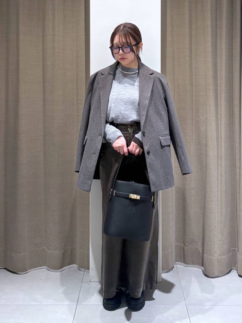 ブラウン系のテーラードジャケット、グレー系のニット/セーター、ブラウン系のスカートを着用したレディースの秋コーディネートの1枚目の写真