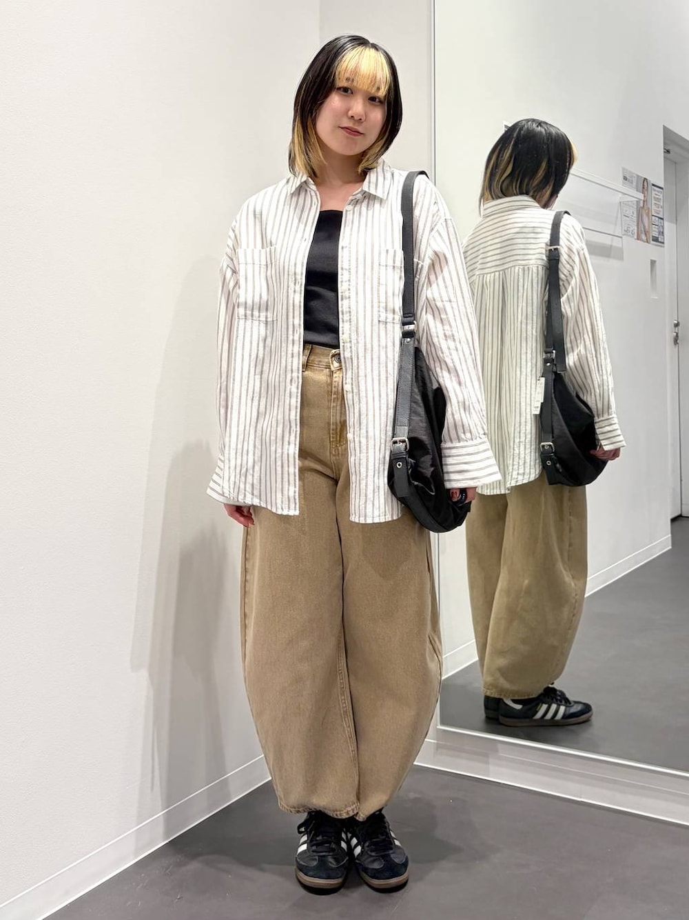 ベージュ系のデニムパンツ、ブラック系のショルダーバッグ、ホワイト系のシャツ/ブラウスを着用したレディースの春コーディネートの1枚目の写真