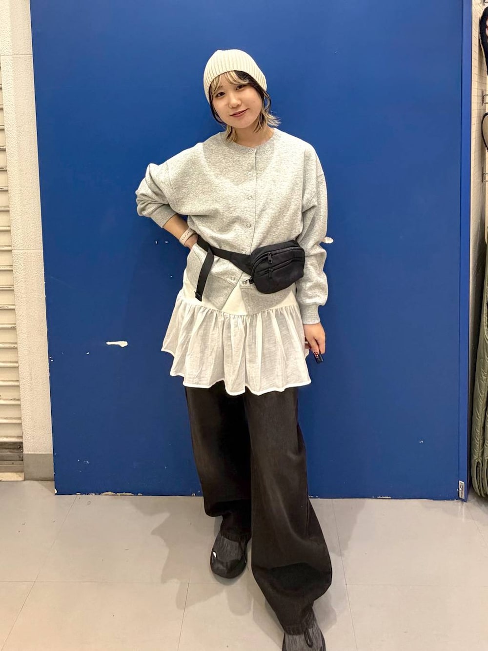 ブラック系のボディバッグ/ウエストポーチ、ブラック系のデニムパンツ、ホワイト系のタンクトップを着用したレディースの秋コーディネートの1枚目の写真