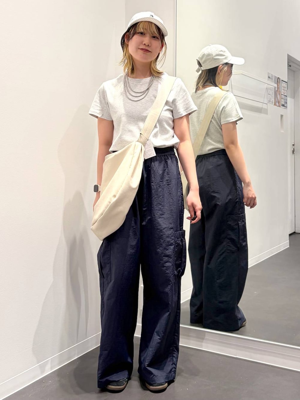 グレー系のTシャツ/カットソー、ブルー系のカーゴパンツ、ホワイト系のショルダーバッグを着用したレディースの春コーディネートの1枚目の写真
