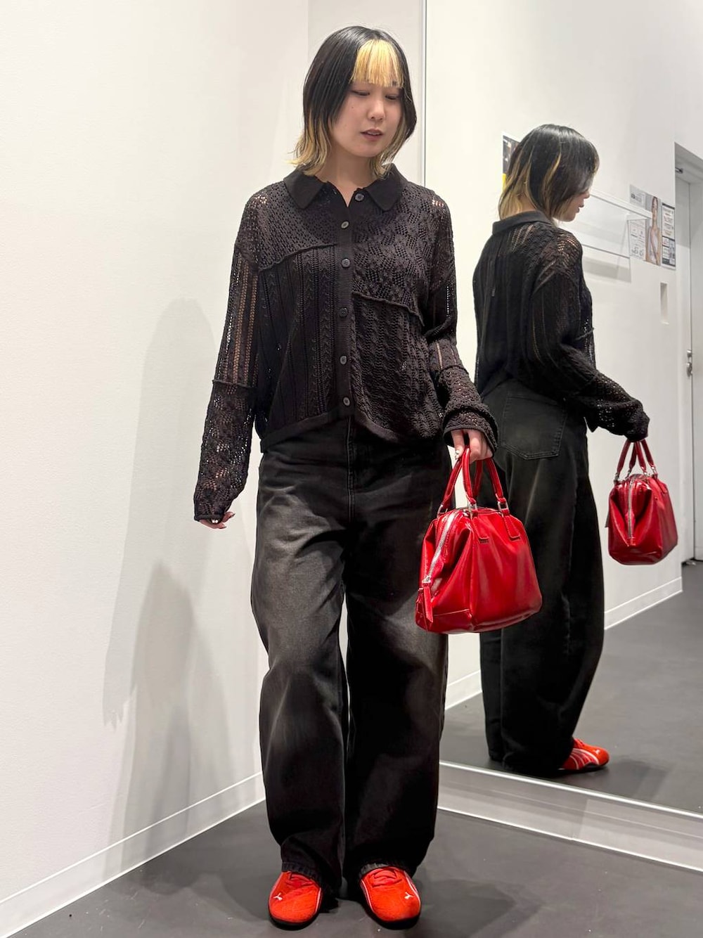 ブラック系のデニムパンツ、レッド系のスニーカー、ブラック系のタンクトップを着用したレディースの春コーディネートの1枚目の写真