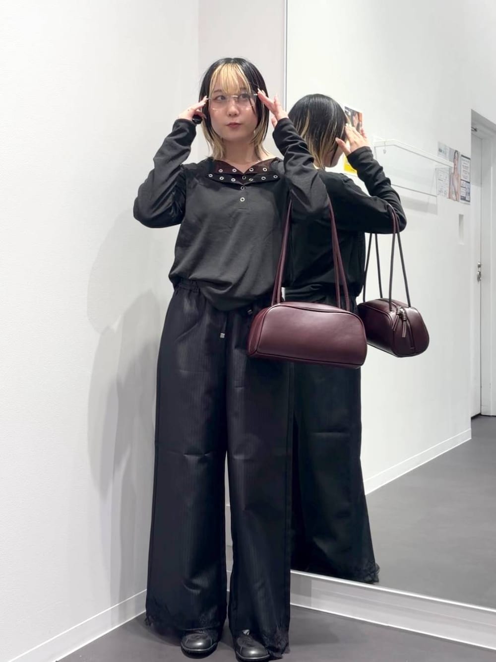レッド系のボストンバッグ、ブラック系のスラックス、ブラック系のTシャツ/カットソーを着用したレディースの夏コーディネートの1枚目の写真